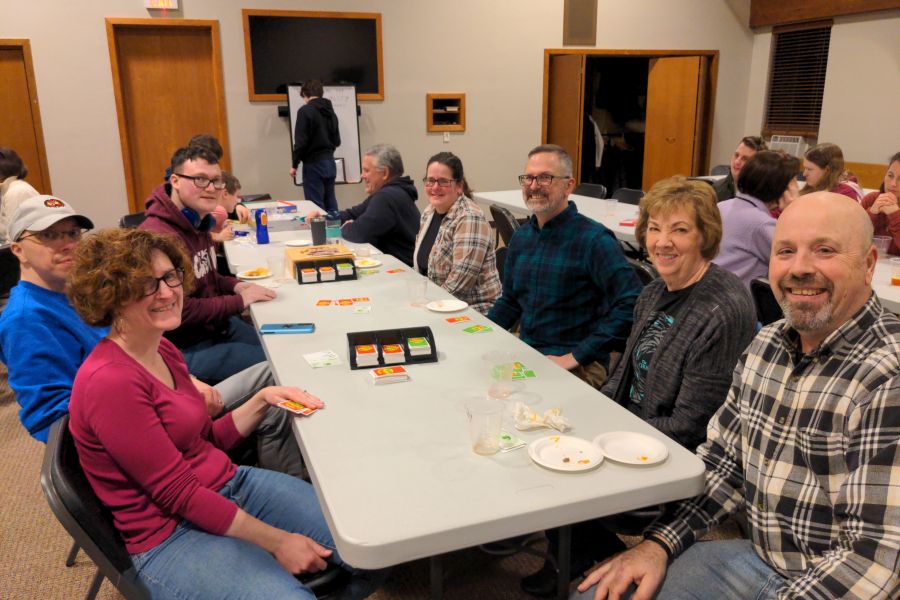 Adults smiling around a table at church game night