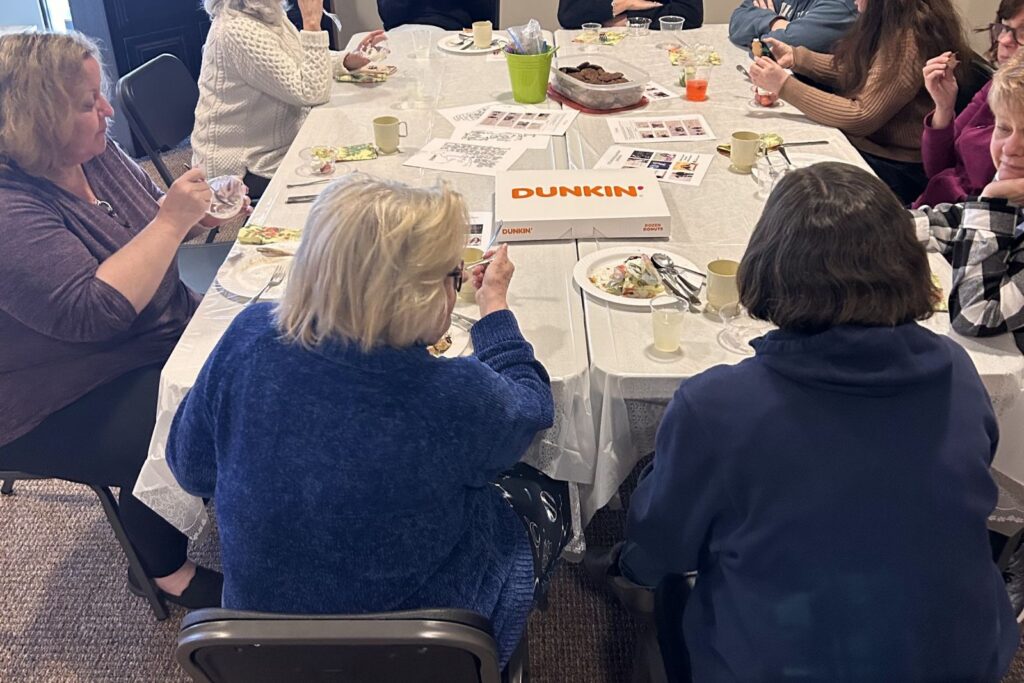 Women talking and laughing around a table at a women’s ministry gathering